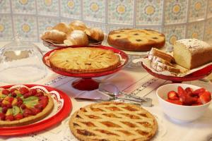 ボルミオにあるMeublè Cima Bianca Garniのパイ、パン、フルーツの盛り合わせが並ぶテーブル