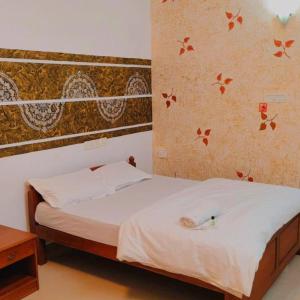 a bedroom with a bed with white sheets at Peninsular wood Resort in Thattakād