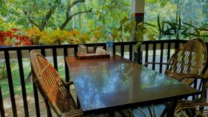 a table and two chairs on a balcony with a table and chairs at Peninsular wood Resort in Thattakād