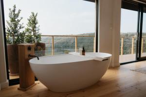 a bath tub in a room with a large window at Ocean's Edge - Private Nature Reserve in George +39 photos