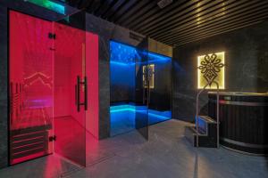 a bathroom with a shower with red and blue lights at Black Mountain Residence & SPA, Odkryj-Białkę in Białka Tatrzańska