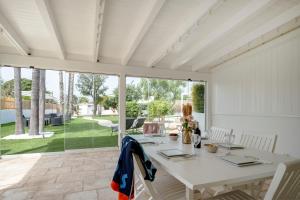 a white dining room with a white table and chairs at GuestHost - Lume di Mare in Faccia di Trippa