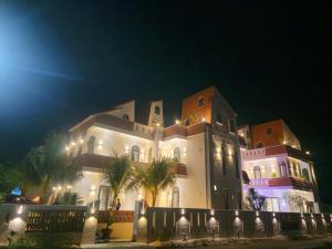 a large white building with palm trees at night at Gió nồm in Phú Hiệp
