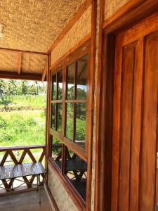 a room with a window and a bench on a porch at Konbayan Forest Stay in Bayan