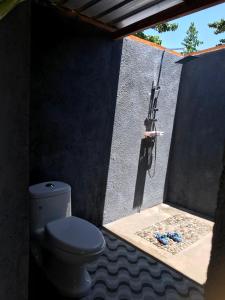 a bathroom with a toilet and a gun on the wall at Konbayan Forest Stay in Bayan