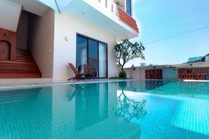 a swimming pool with two chairs and a building at Gió nồm in Phú Hiệp