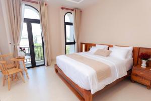 a bedroom with a bed and a table and windows at Gió nồm in Phú Hiệp