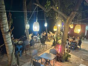 a group of people sitting at a restaurant at night at PAKBENG SUNSET DORM Room in Pakbeng