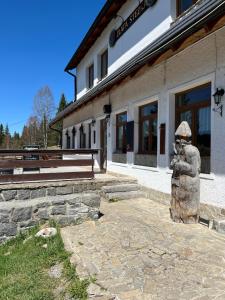 a statue of a person in front of a building at Zlatá Stezka in Modrava