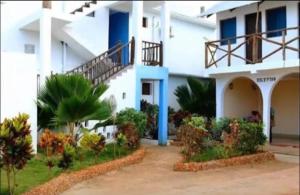 a white building with a staircase in front of it at 27Azmaa hotel & safaris in Zanzibar City