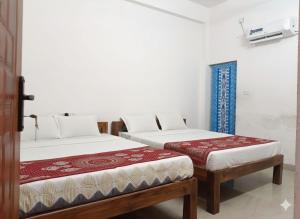 two twin beds in a room at Jo Inn Beach View Guest House in Kuilapayam +11 photos