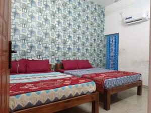 a room with two beds and a couch in it at Jo Inn Beach View Guest House in Kuilapayam