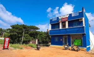 a blue building with two motorcycles parked in front of it at Jo Inn Beach View Guest House in Kuilapayam