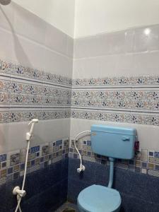 a bathroom with a blue toilet in a room at Jo Inn Beach View Guest House in Kuilapayam