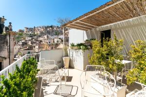 ein Balkon mit Stühlen und Blick auf die Stadt in der Unterkunft Iblaresort Boutique Hotel in Ragusa