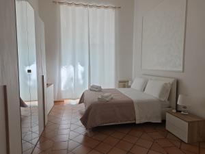 a white bedroom with a bed and a tiled floor at Liberty House Ten in Rome