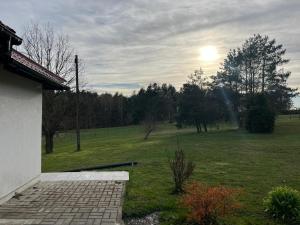 a view of a yard with a field and a house at Cozy Forest House in Jonkowo +5 photos