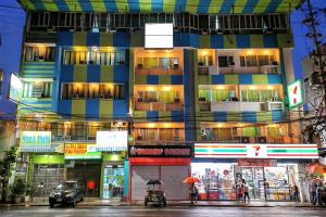 a tall building with people walking in front of it at Yuj Inn Pasay in Manila