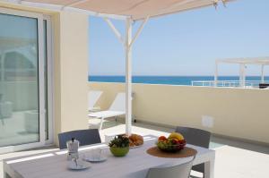 a table with a bowl of fruit on a balcony at Cicirìa - Private Seafront Suites in Avola