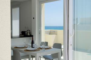 a white dining room with a white table and chairs at Cicirìa - Private Seafront Suites in Avola