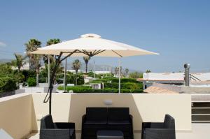 a patio with two chairs and an umbrella at Cicirìa - Private Seafront Suites in Avola +102 photos