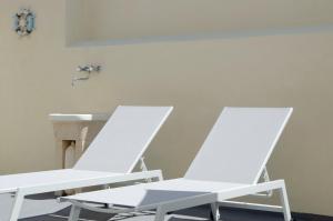 two white chairs sitting next to a sink at Cicirìa - Private Seafront Suites in Avola