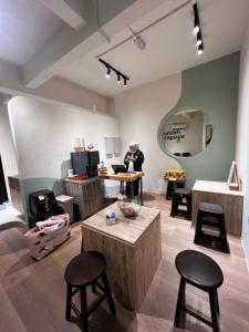a woman standing in a room with a table and stools at Urban Capsule by Faradale in Kuching