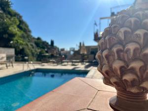 a vase sitting on a ledge next to a pool at Hotel Soleado in Taormina