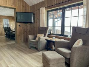 a living room with chairs and a tv and a table at Tyinkrysset panorama in Tyinkrysset