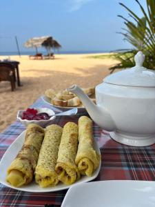 a plate of food on a table on the beach at Sea View Villa Bentota, Induruwa in Induruwa