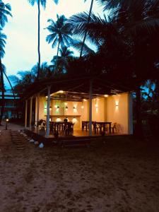 a restaurant on the beach at night with palm trees at Sea View Villa Bentota, Induruwa in Induruwa