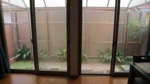 a room with sliding glass doors with trees outside at Sakuraya 亀島店 in Nagoya