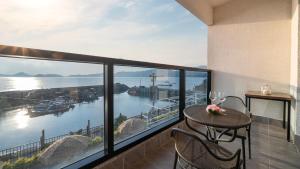 a balcony with a table and chairs and a view of the water at Yeosu Wayo Ocean View Pension in Yeosu