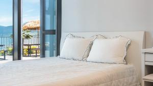 a bedroom with a bed with a view of the ocean at Yeosu Wayo Ocean View Pension in Yeosu