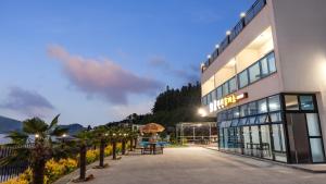a hotel with palm trees in front of a building at Yeosu Wayo Ocean View Pension in Yeosu