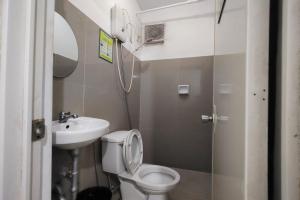 a small bathroom with a toilet and a sink at Yuj Inn Pasay in Manila +44 photos