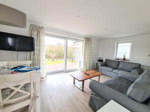 a living room with a couch and a table at Lütt Hüs 1 in Wenningstedt