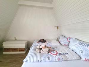 a bedroom with a bed with a teddy bear on it at Lütt Hüs 1 in Wenningstedt