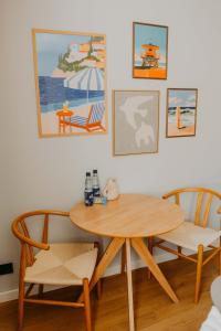 a dining room table and chairs with paintings on the wall at sleepArt beach in Celle +13 photos
