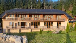 a large house with a large balcony on a mountain at Penzión JANÍK JASNÁ in Belá