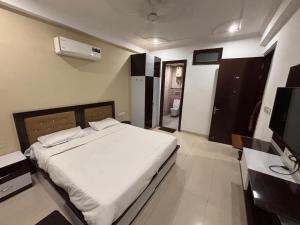 a bedroom with a white bed and a television at Tranquil Bliss in Jāmb +5 photos