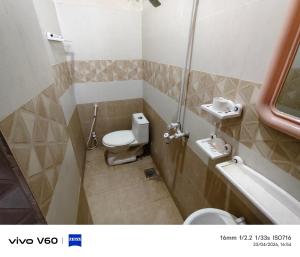 a small bathroom with a toilet and a sink at Al Qadir Residence in Multan