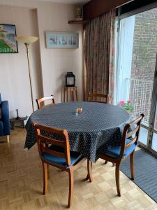 a table and chairs in a room with a window at Gîte MAÏ - Classé 3 étoiles in Dieppe +24 photos