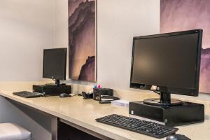 a desk with a computer monitor and a keyboard at Staybridge Suites - Pecos by IHG in Pecos