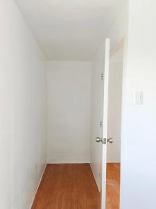 an empty room with white walls and a wooden floor at camella palawan in Puerto Princesa City