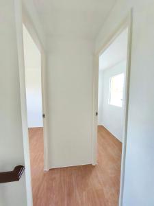 an empty room with two doors and a wooden floor at camella palawan in Puerto Princesa City