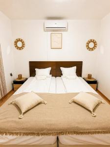 a bedroom with a large bed with two pillows at Къща за гости "Холидей" - Луковит in Lukovit