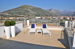two chairs and a table on a balcony with a mountain at Hotel Del Conte in Fondi