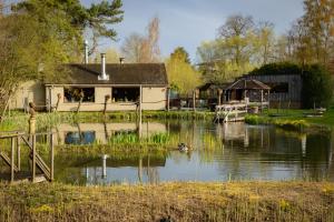 a house on a river with a boat in the water at Thermae Grimbergen Hotel in Grimbergen