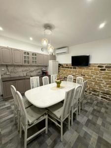 a kitchen with a table and chairs in a room at Къща за гости "Холидей" - Луковит in Lukovit
